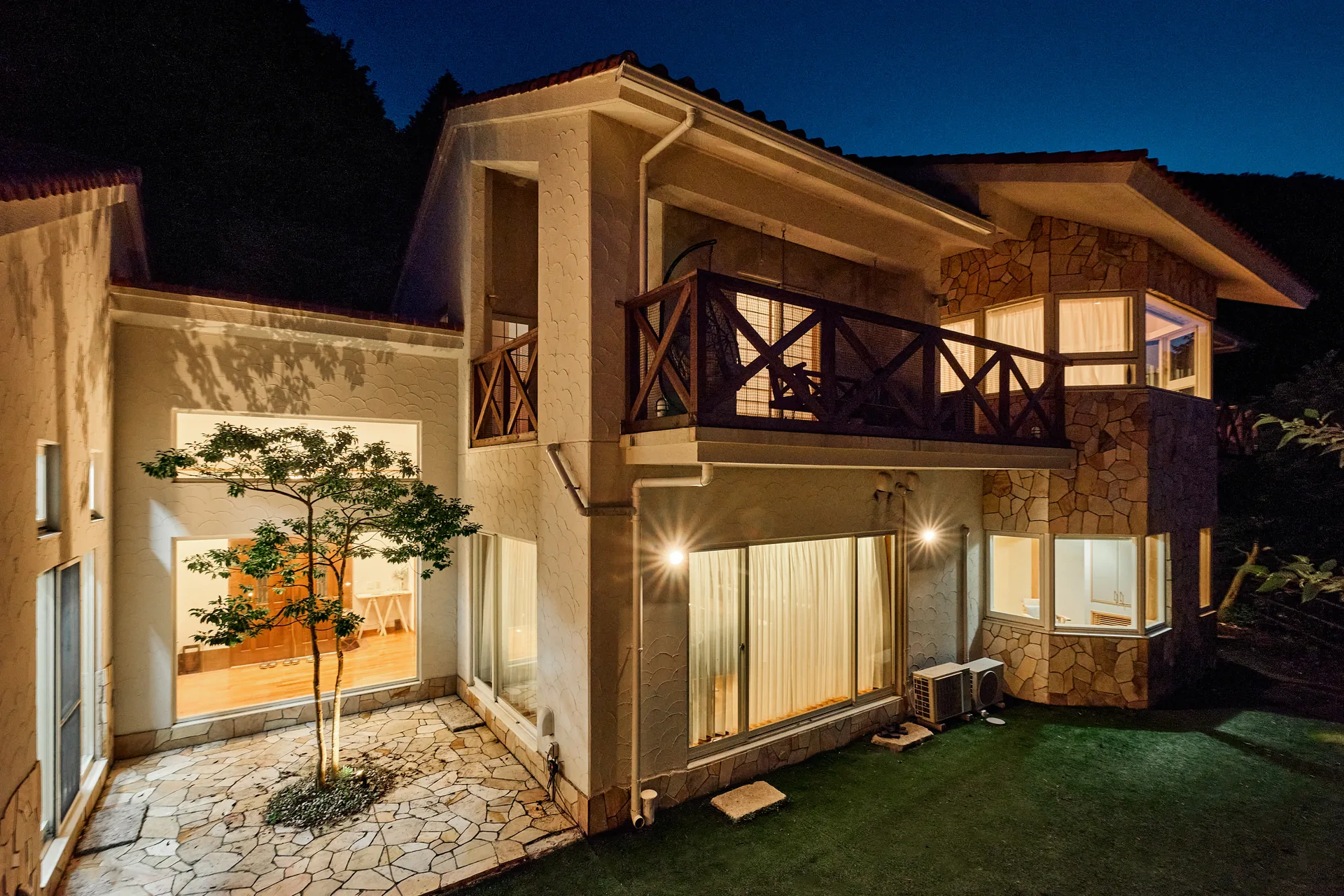 夜の帳に灯りがともる白壁の建物全景
