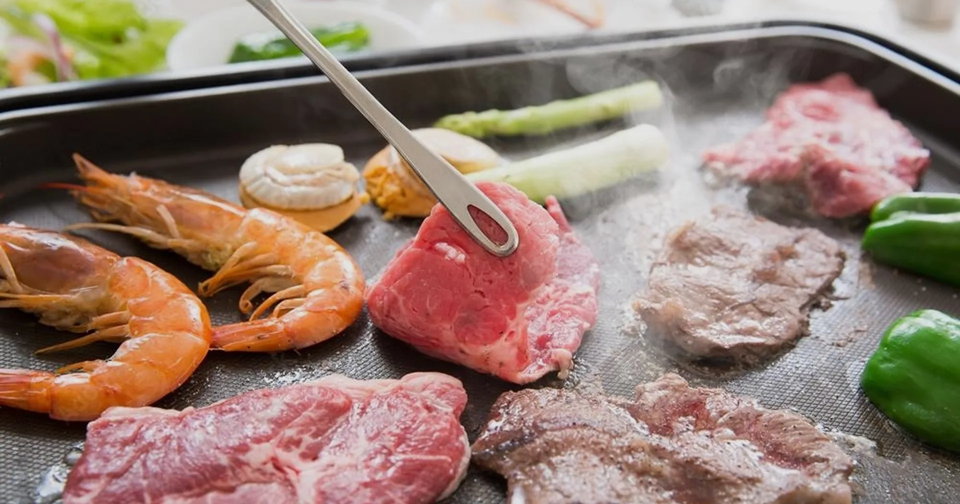 BBQグリルで焼き上がるエビや肉、野菜