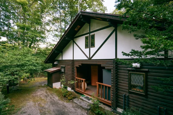 森の中に佇むハーフティンバーの建物外観と玄関ポーチ